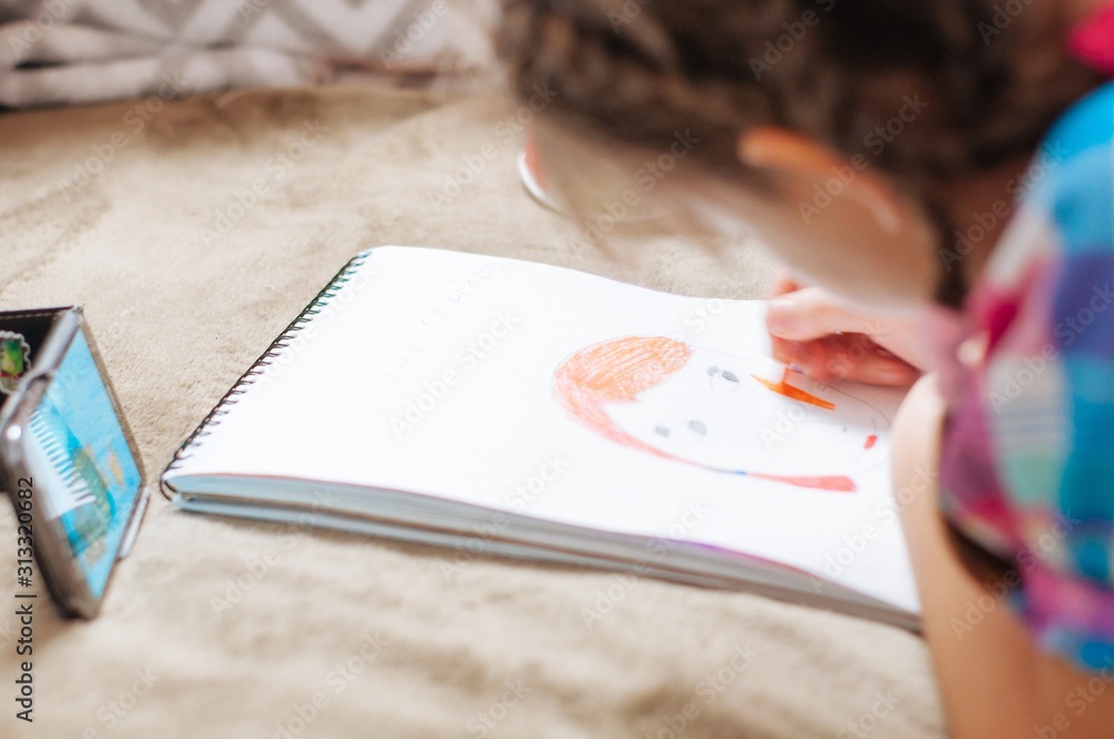 cute little girl drawing pictures while lying on bed cute little girl drawing pictures while lying on bed