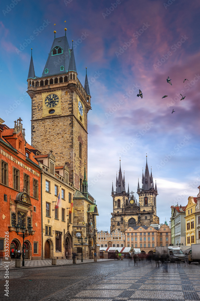 Prague, Czech Republic - The Old Town Square with Old City Hall building with the Astronomical Clock tower and Church of Our Lady before Týn on a December afternoon with purple clouds and pigeons