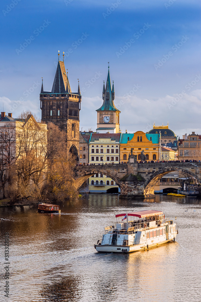 Prague, Czech Republic - Beautiful golden sunset and blue sky at the world famous Charles Bridge (Karluv most) and Old Town Water Tower on a winter afternoon