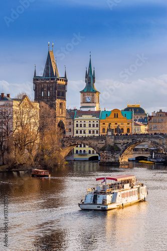 Obraz na płótnie Prague, Czech Republic - Beautiful golden sunset and blue sky at the world famous Charles Bridge (Karluv most) and Old Town Water Tower on a winter afternoon w salonie