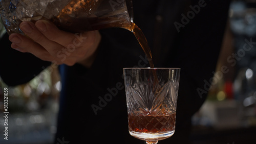 Pouring prepared cocktail into glass