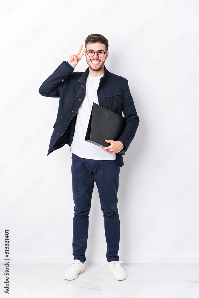 Young caucasian man full body isolated showing victory sign and smiling broadly. Young caucasian man full body isolated showing victory sign and smiling broadly.