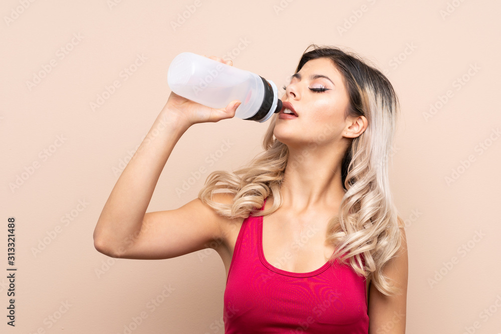 Teenager sport girl over isolated background with sports water bottle Teenager sport girl over isolated background with sports water bottle