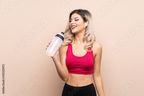 Teenager sport girl over isolated background with sports water bottle
