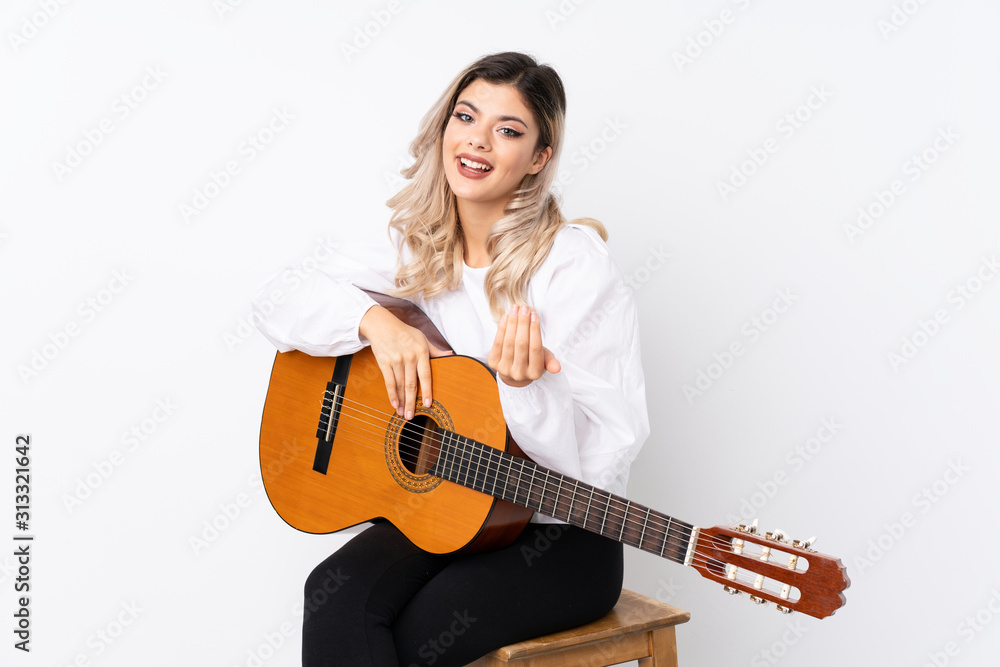 Teenager girl with guitar over isolated white background inviting to come with hand. Happy that you came Teenager girl with guitar over isolated white background inviting to come with hand. Happy that you came