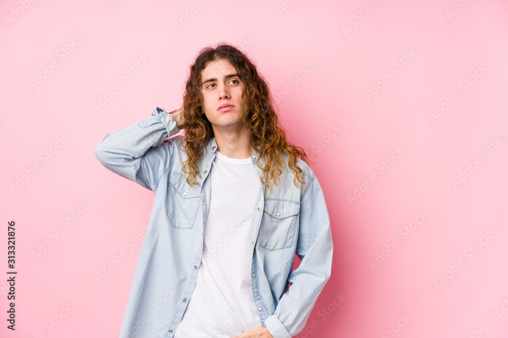 Long hair man posing isolated touching back of head, thinking and making a choice. Long hair man posing isolated touching back of head, thinking and making a choice.