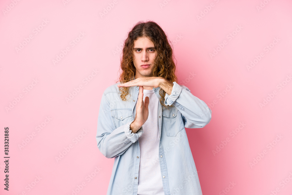 Long hair man posing isolated showing a timeout gesture. Long hair man posing isolated showing a timeout gesture.
