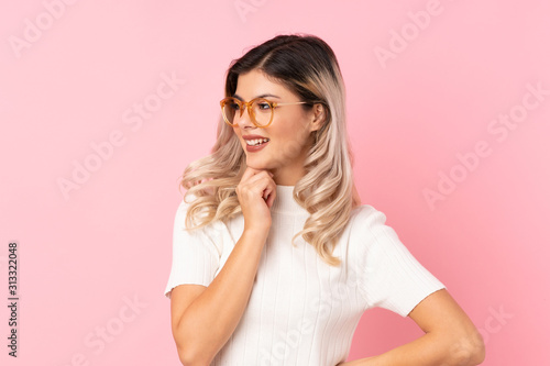 Teenager girl over isolated pink background with glasses