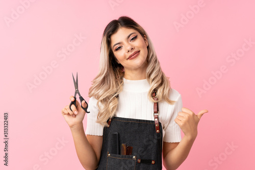 Φωτογραφία Teenager girl over isolated pink background with hairdresser or barber dress and