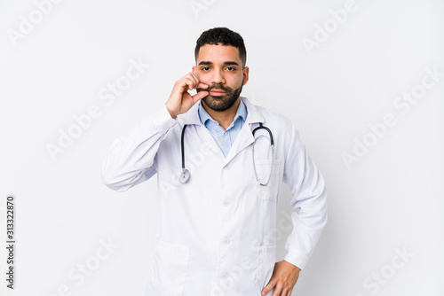 Young arabian doctor man isolated with fingers on lips keeping a secret.