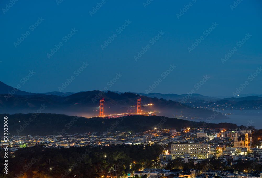 Obraz premium View of the Golden Gate Brdige At Night With Fog Over the Bay