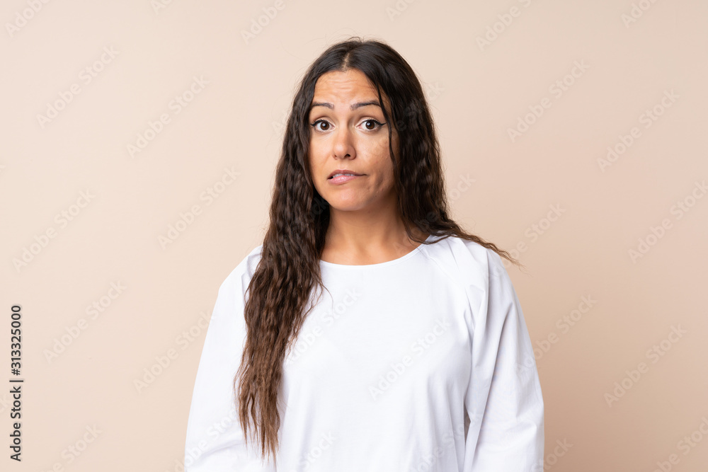 Young woman over isolated background having doubts and with confuse face expression Young woman over isolated background having doubts and with confuse face expression