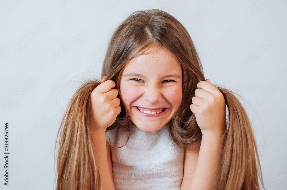 Fototapeta premium Little girl face portrait in Girl child brush hair in fashionable dress