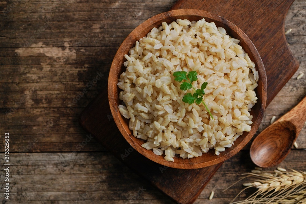 Bowl of cooked Whole grain brown rice on wooden background overhead view Bowl of cooked Whole grain brown rice on wooden background overhead view