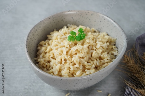 Bowl of cooked Whole grain brown rice  on wooden background overhead view photo