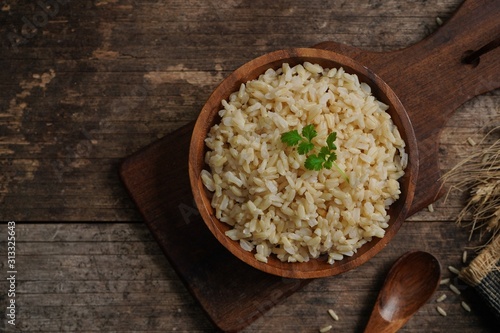 Bowl of cooked Whole grain brown rice  on wooden background overhead view