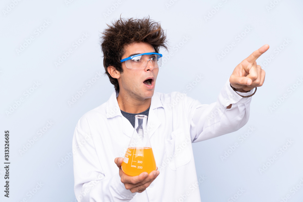Young scientific man over isolated blue background pointing away Young scientific man over isolated blue background pointing away