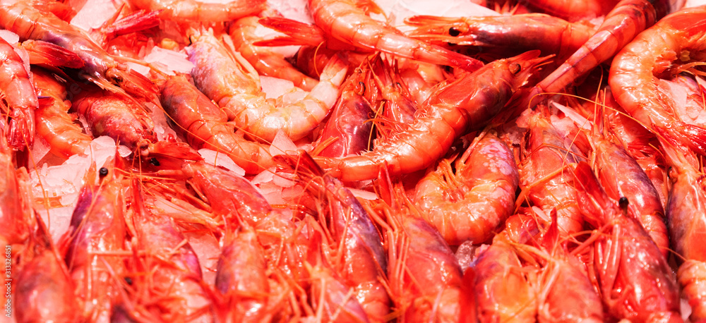Top view to shrimps on display on ice in fisherman market store in Spanish market