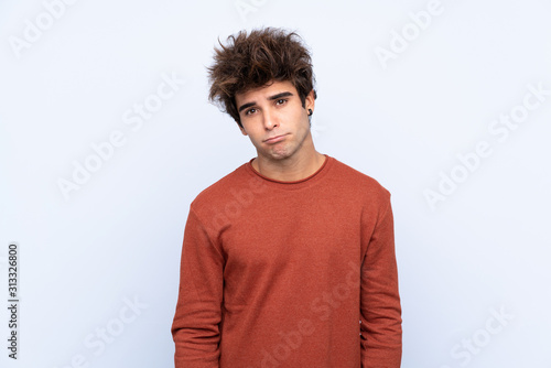 Young caucasian man over isolated blue background with sad and depressed expression