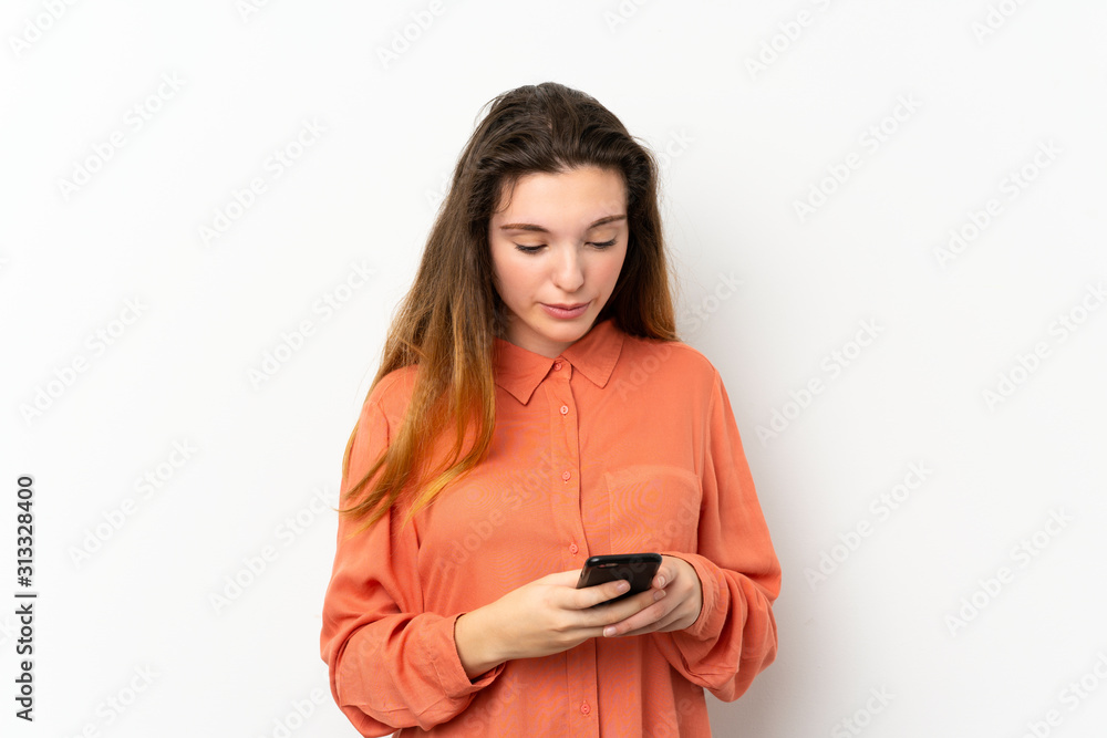 Obraz premium Young brunette girl over isolated white background sending a message with the mobile