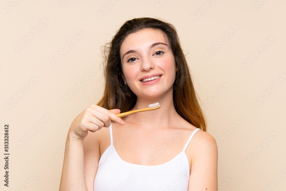 Young brunette girl brushing her teeth.over isolated background Young brunette girl brushing her teeth.over isolated background