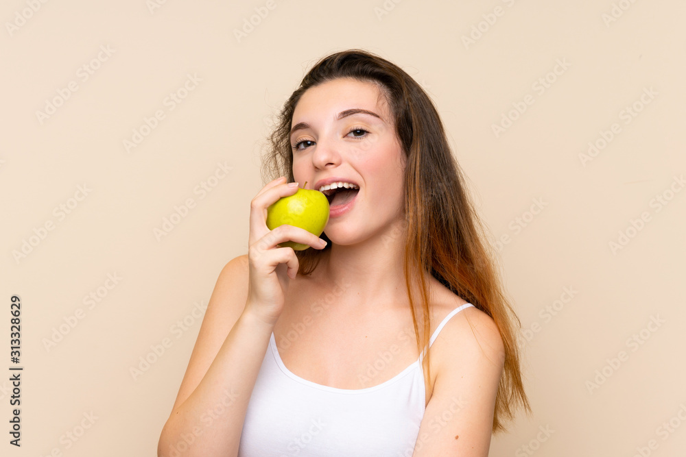 Young brunette girl with an apple over isolated background Young brunette girl with an apple over isolated background