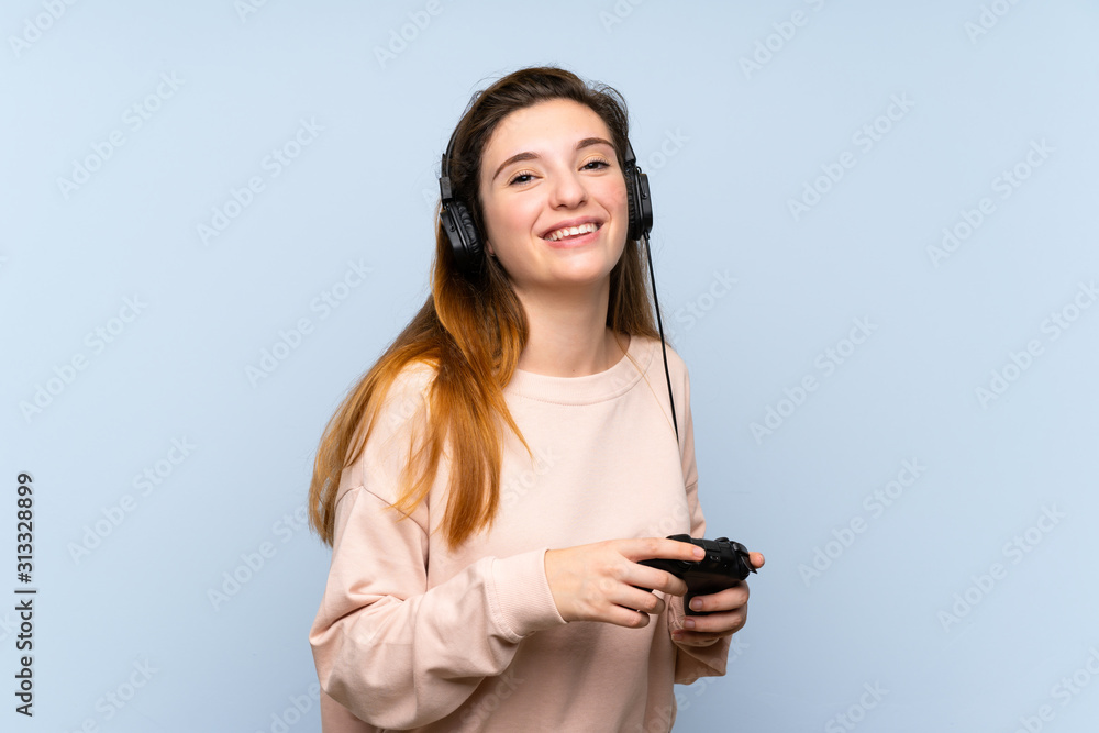 Young brunette girl over isolated blue background playing at videogames Young brunette girl over isolated blue background playing at videogames