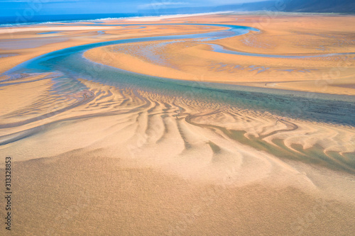 Fototapeta Naklejka Na Ścianę i Meble -  Aerial drone view of icelandic Raudasandur beach with azure water streams and yellow sand