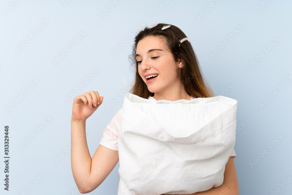 Young woman in pajamas over isolated blue background celebrating a victory Young woman in pajamas over isolated blue background celebrating a victory