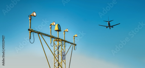 Drone zone sign on approach lighting system at runway. Airport airspace prohibition drones fly sign. Flying plane in background.	