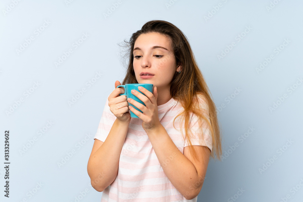 Young brunette girl holding a cup of coffee over isolated background Young brunette girl holding a cup of coffee over isolated background