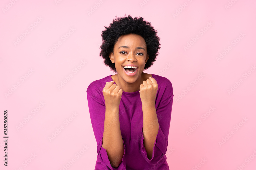 African american woman over isolated pink background celebrating a victory in winner position African american woman over isolated pink background celebrating a victory in winner position