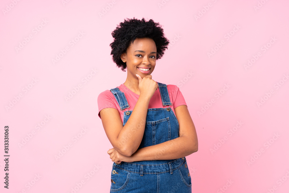 African american woman with overalls over isolated pink background laughing African american woman with overalls over isolated pink background laughing