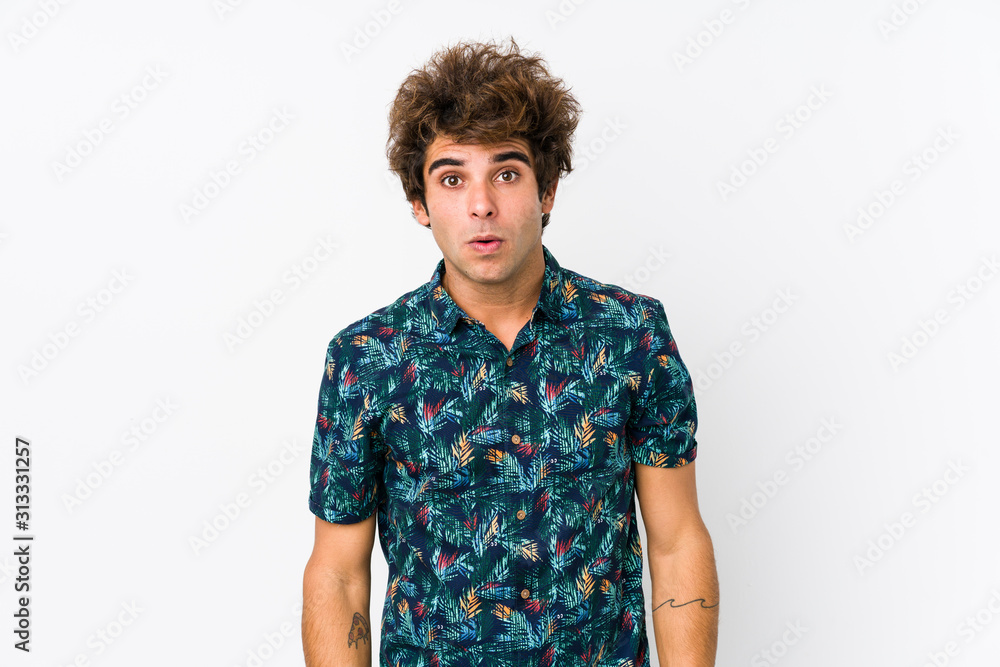Young caucasian man wearing a flower t-shirt isolated shrugs shoulders and open eyes confused. Young caucasian man wearing a flower t-shirt isolated shrugs shoulders and open eyes confused.