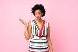 African american woman over isolated pink background making doubts gesture
