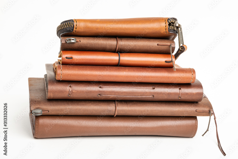 A Stack Of Leather-Bound Journals, Notebooks, Wallets & Cases A Stack Of Leather-Bound Journals, Notebooks, Wallets & Cases