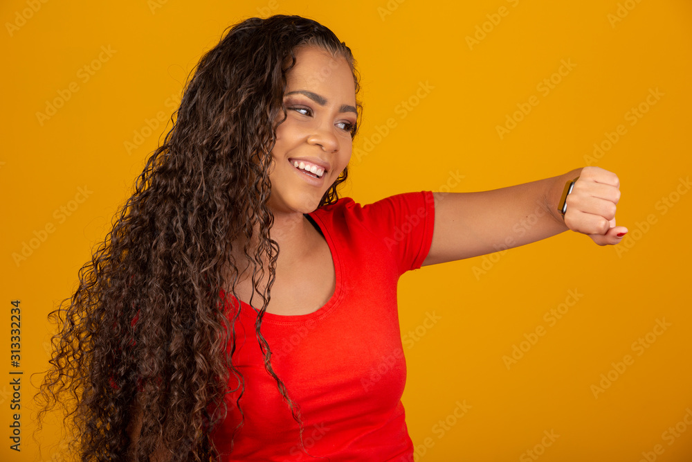 Close up of woman hands setting smart watch. Technology and people concept. Young woman looking at the time or other content on her smart watch. On yellow background. Close up of woman hands setting smart watch. Technology and people concept. Young woman looking at the time or other content on her smart watch. On yellow background.