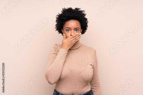 African american woman over isolated background covering mouth with hands