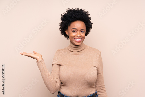 African american woman over isolated background holding copyspace imaginary on the palm to insert an ad