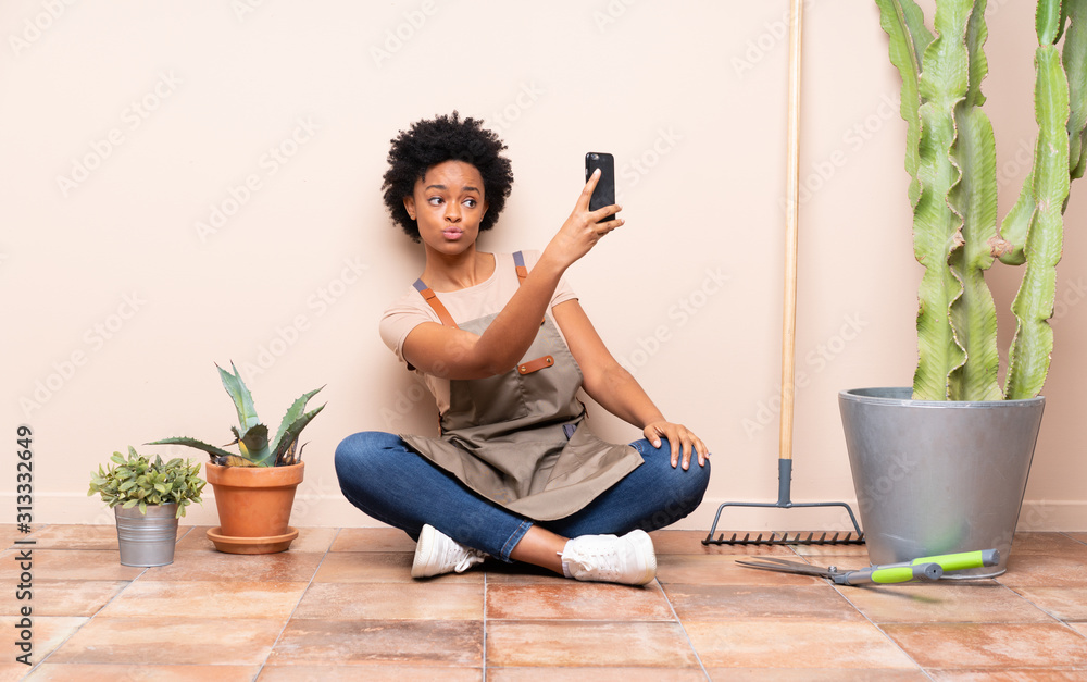 Gardener woman sitting on the floor making a selfie Gardener woman sitting on the floor making a selfie