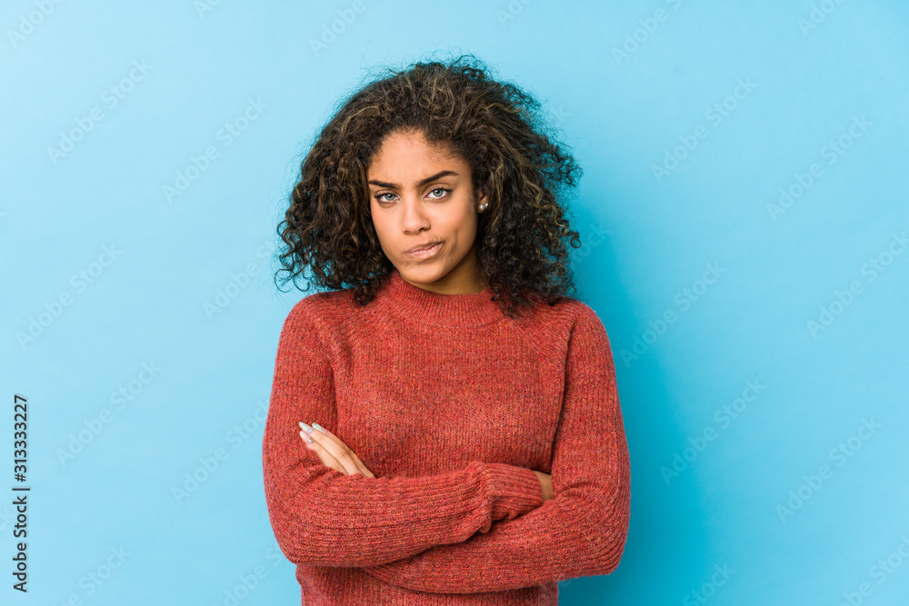 Young african american curly hair woman frowning face in displeasure, keeps arms folded. Young african american curly hair woman frowning face in displeasure, keeps arms folded.