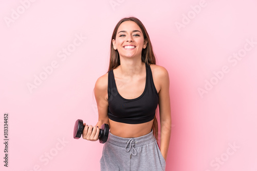 Young caucasian sporty woman holding a dumbbell