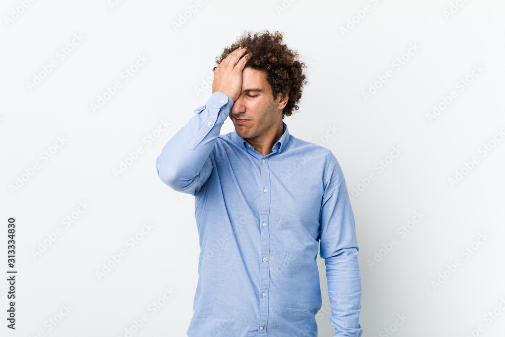 Young curly mature man wearing an elegant shirt forgetting something, slapping forehead with palm and closing eyes. Young curly mature man wearing an elegant shirt forgetting something, slapping forehead with palm and closing eyes.