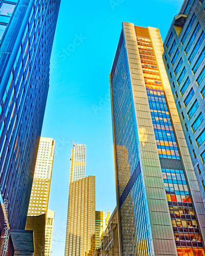 Bottom up Street view on Financial District of Lower Manhattan  New York City  NYC  USA. Skyscrapers tall glass buildings United States of America. Blue sky on background. Empty place for copy space.