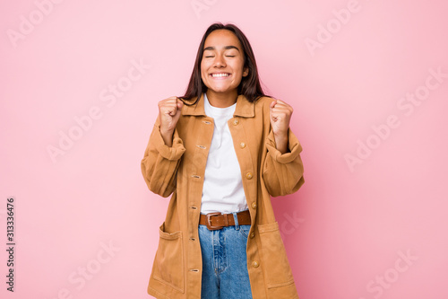 Young mixed race indian woman isolated raising fist, feeling happy and successful. Victory concept. © Asier
