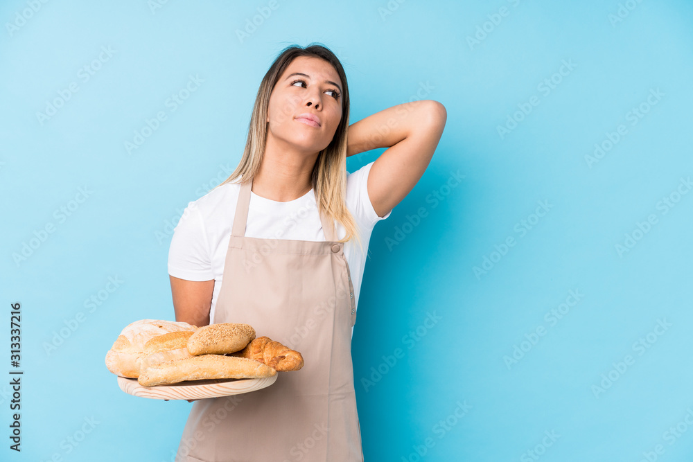 Young caucasian baker woman isolated touching back of head, thinking and making a choice. Young caucasian baker woman isolated touching back of head, thinking and making a choice.