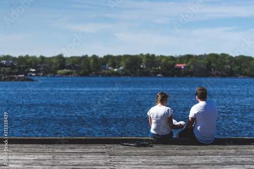 Young couple sitting beside the water. 