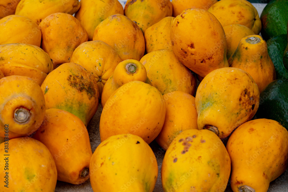 Fresh papayas are stacked and piled at a Farmers Market on Kauai, ready for sale. 
