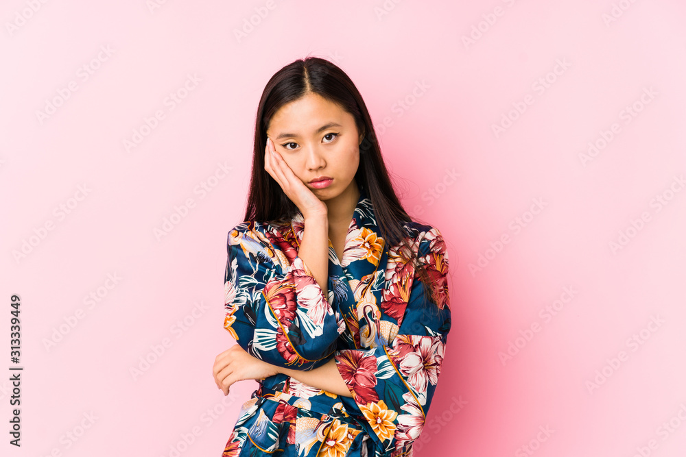 Young chinese woman wearing a kimono pajama isolated who is bored, fatigued and need a relax day. Young chinese woman wearing a kimono pajama isolated who is bored, fatigued and need a relax day.