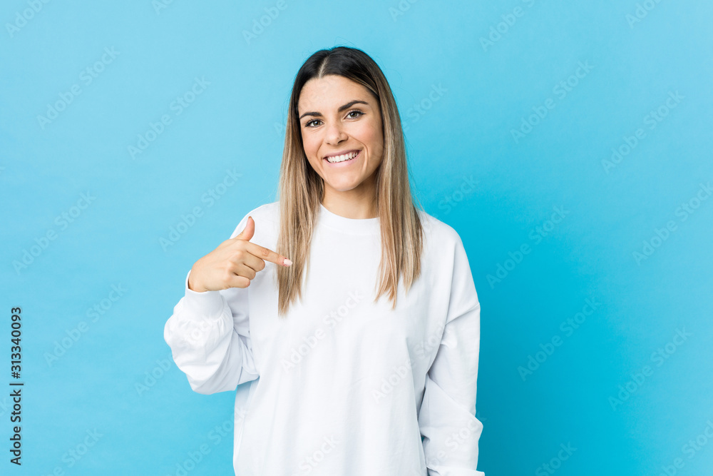 Young caucasian woman isolated person pointing by hand to a shirt copy space, proud and confident Young caucasian woman isolated person pointing by hand to a shirt copy space, proud and confident